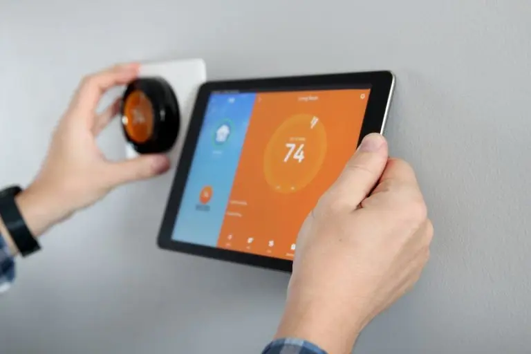 Man is Adjusting a temperature using a tablet with a smart home app