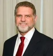 Vic Nigri professional corporate headshot in a dark suit and red tie