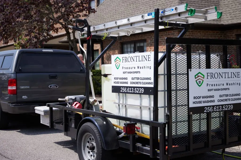 Local Pressure Washing Company service trailer with signs and ladder