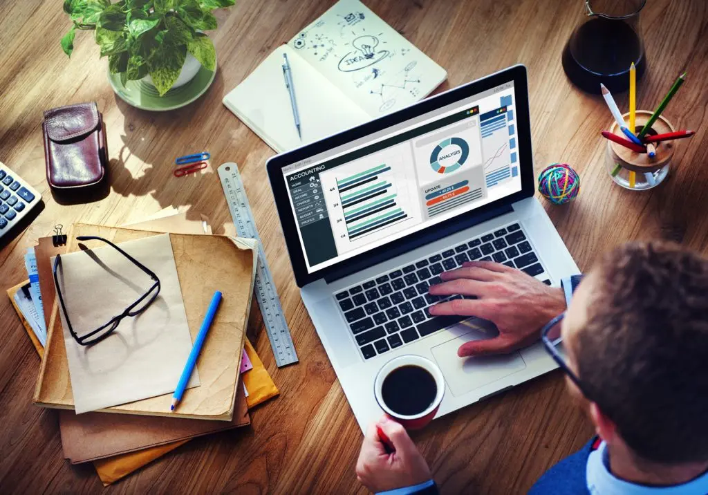 Accountant analyzing financial data charts on a laptop screen desk