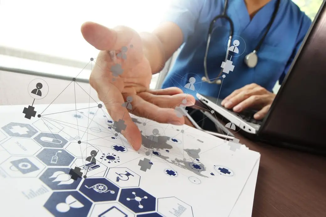 A medical professional in blue scrubs reaching out over a digital network overlay and healthcare graphics, highlighting modern healthcare marketing and patient data communication