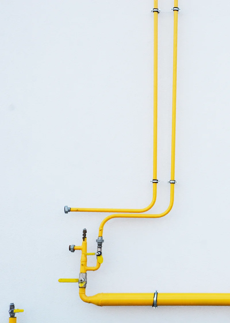 gas yellow pipes running along white wall