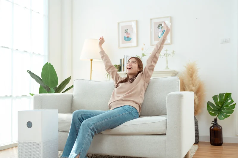 woman relaxing on couch near air purifier