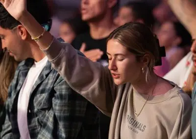 young lady, hands raised worshipping