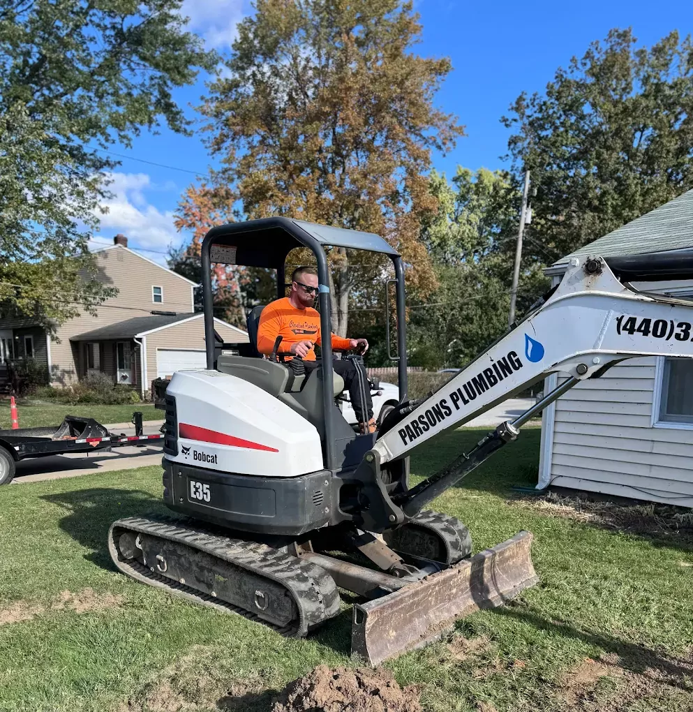 parsons plumbing worker using excavator