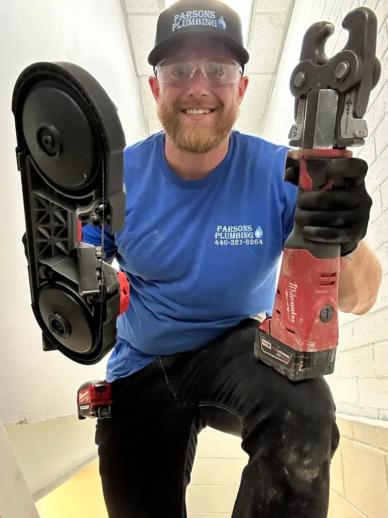 smiling plumber showing his tools