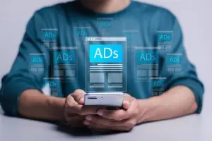 digital marketing and online advertising to targeted customers shooting ads on cross feeds to optimize customer engagement person using mobile smartphone with virtual screen of ads on website