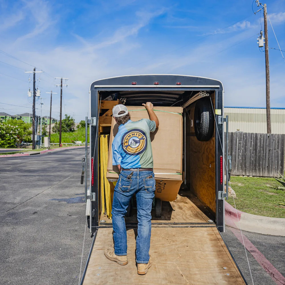 Summit AC crew member loading a box into a company vehicle
