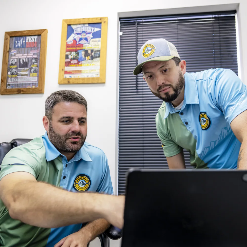 Two Summit AC crew members reviewing work on computer