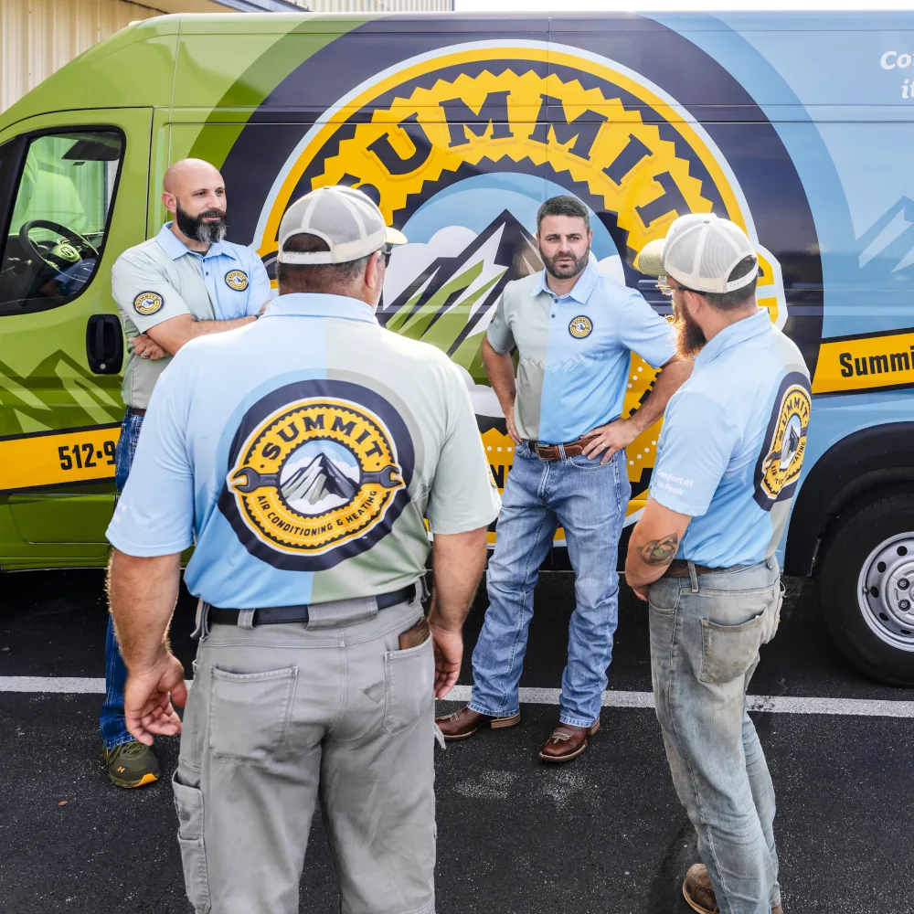Summit AC team members talking outside a van