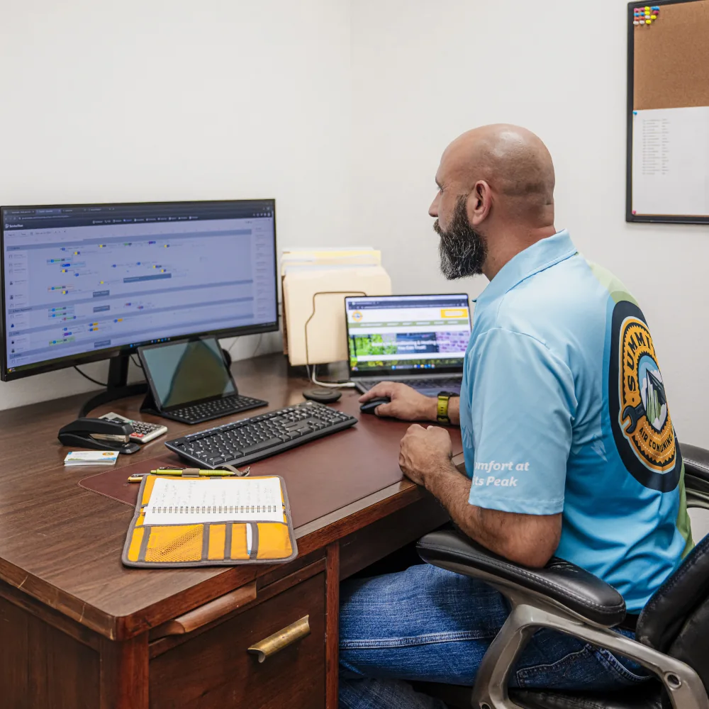 Summit Air Conditioning & Heating team member working on a computer
