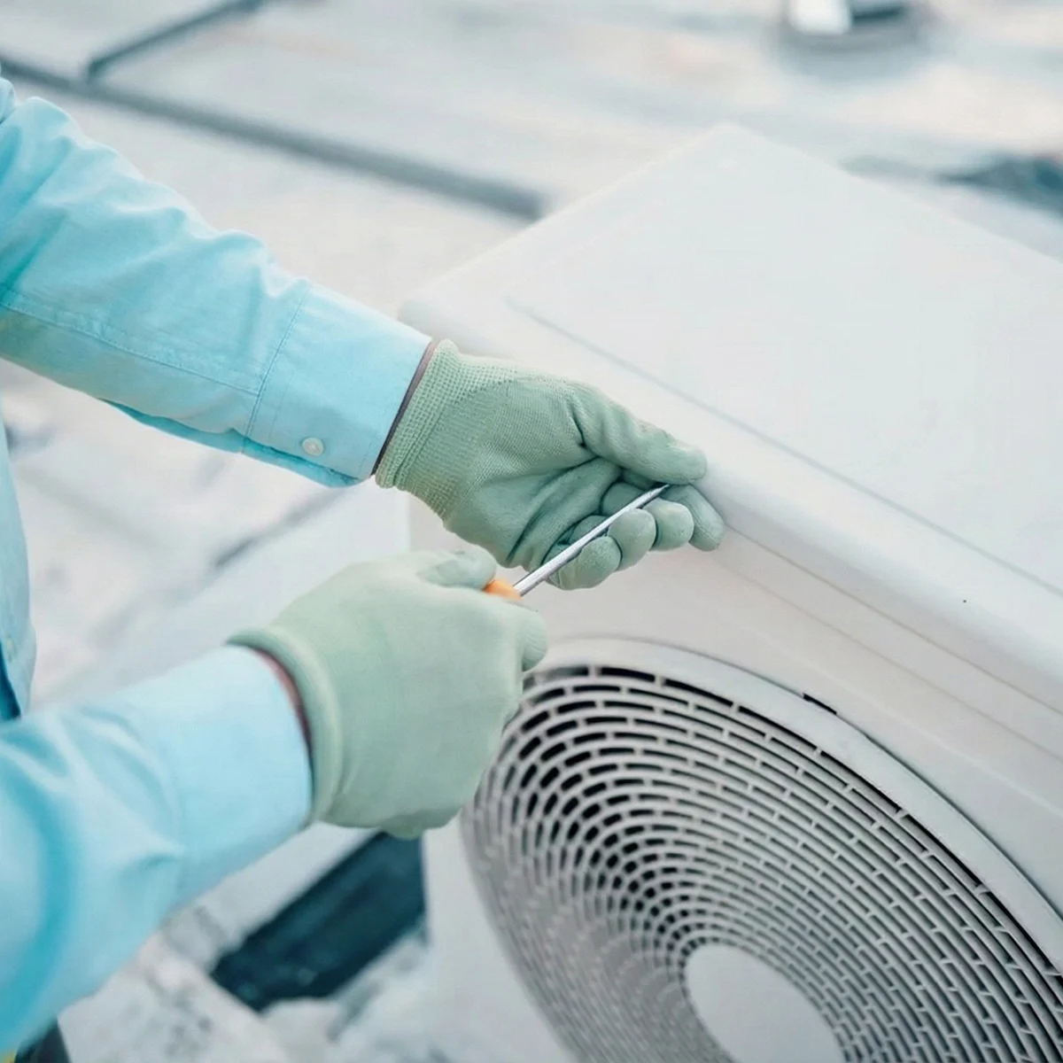 Technician working on an outdoor AC or heat pump unit