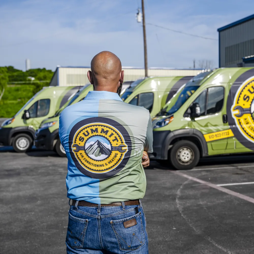 Member of the Summit AC crew looking at company vans