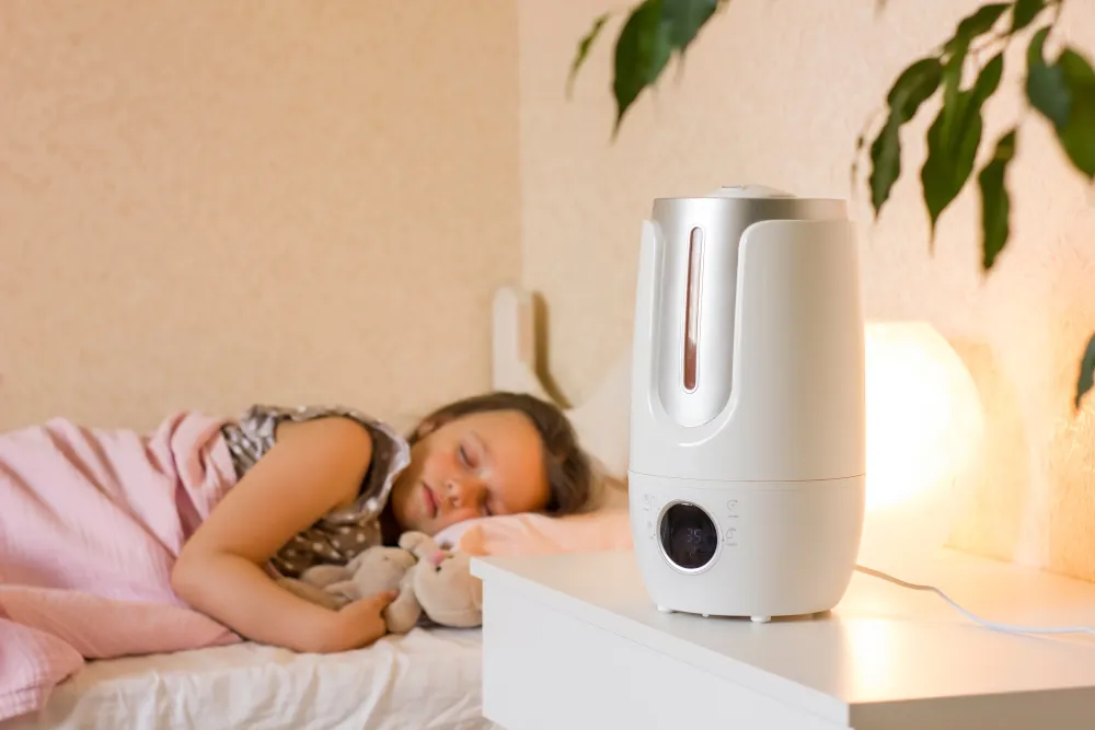 Kid sleeping next to a humidifier