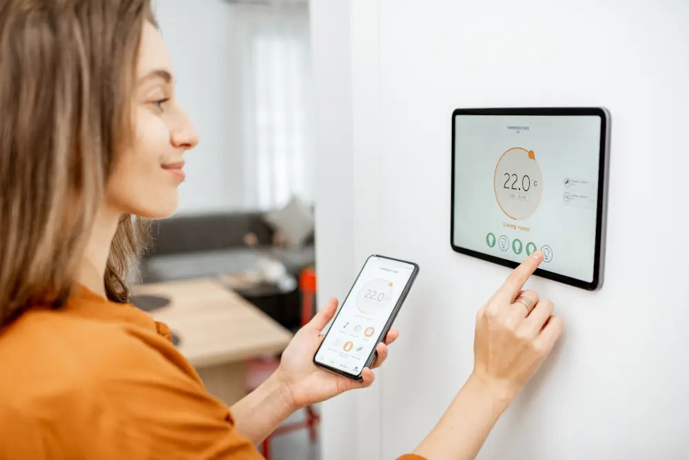 Girl setting the temperature in her smart thermostat
