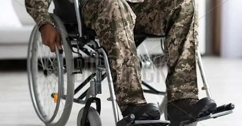 Veteran in military uniform seated in a wheelchair, demonstrating mobility assistance.