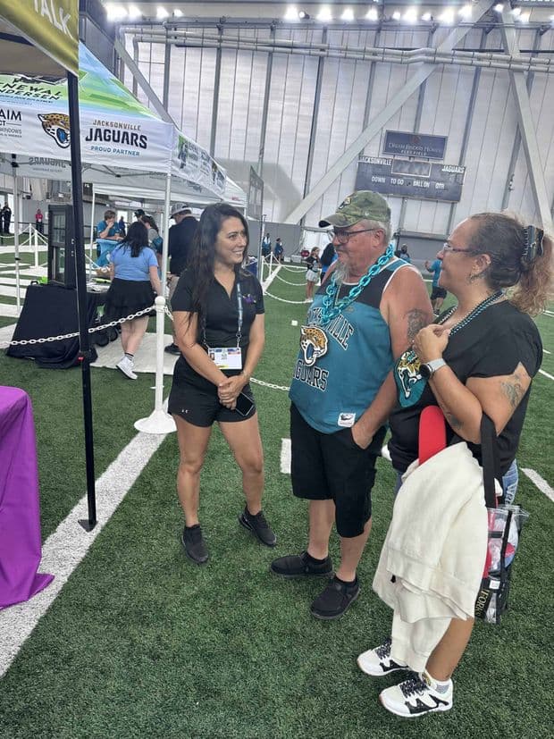 Football fans talking at an indoor stadium event.