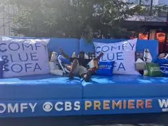 Large blue sofa with "COMFY BLUE SOFA" and CBS PREMIERE logos.