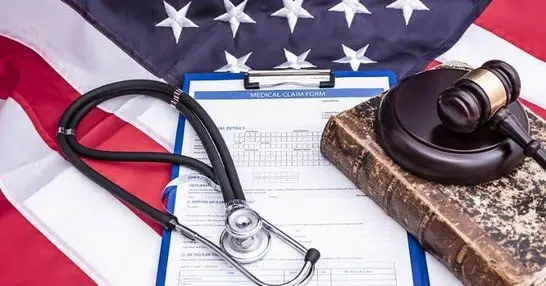 VA disability claim form, gavel, and stethoscope on American flag.