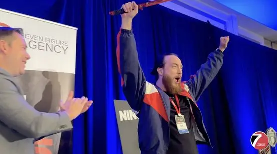 Brady Sticker celebrating on stage at a Seven Figure Agency event