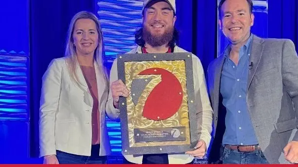Brady Sticker receiving his Seven Figure Agency award with Josh and Yesenia Nelson