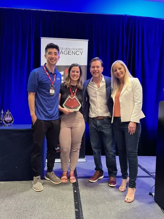 Jennifer accepting a Seven Figure Agency award with Josh and Yesenia Nelson