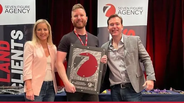 Austin Houser of Base Coat Marketing receiving his Seven Figure Agency award with Josh and Yesenia Nelson