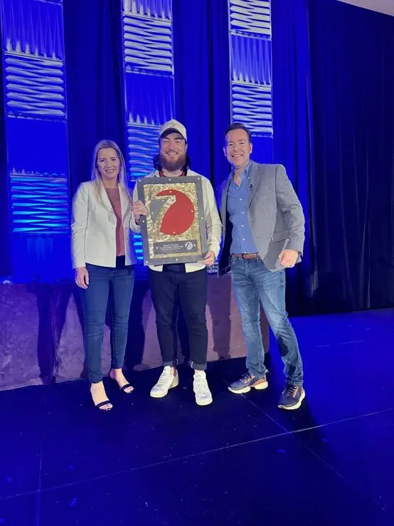 Brady Sticker receiving his Seven Figure Agency award from Josh and Yesenia Nelson