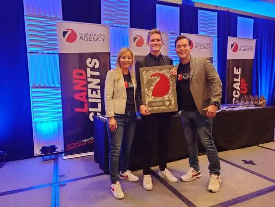 Luke accepting his Seven Figure Agency award with Josh and Yesenia Nelson