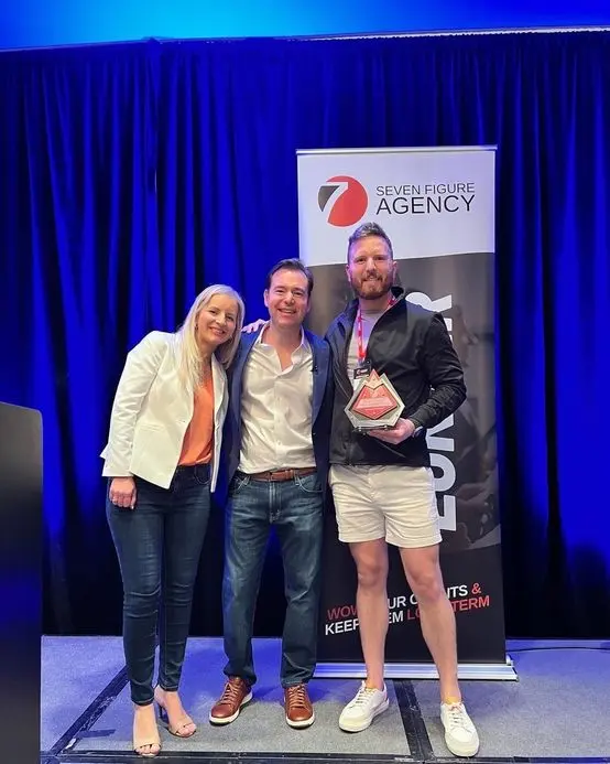 Austin accepting his Seven Figure Agency award with Josh and Yesenia Nelson