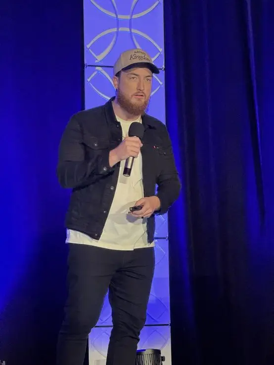 Brady Sticker speaking on stage at a Seven Figure Agency event