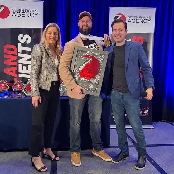 Matt Foreman accepting his Seven Figure Agency award with Josh and Yesenia Nelson