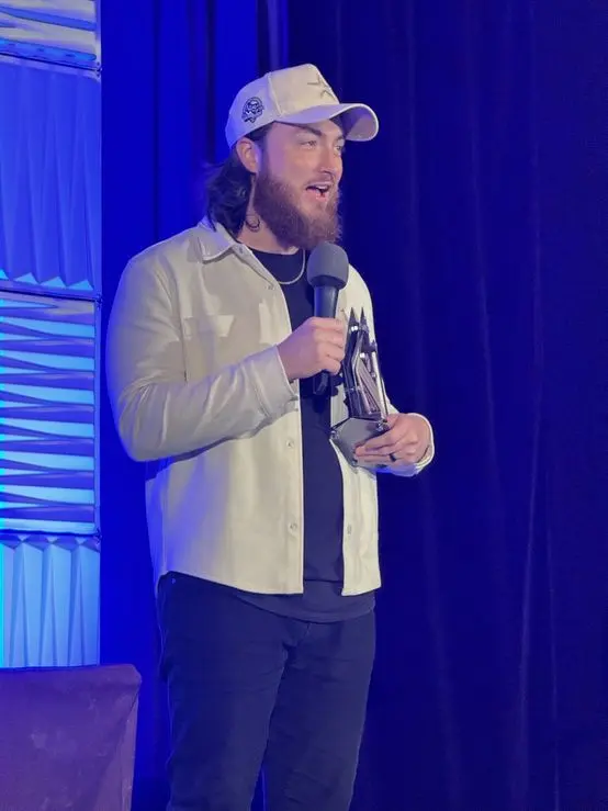 Brady Sticker accepting an award on stage