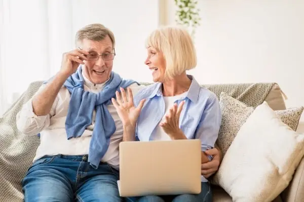 Senior couple reviewing their final expense insurance options on a laptop, securing their financial future in Plano, TX.