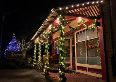 Exterior commercial restaurant decorated for Christmas with live garland lights and santas sleigh