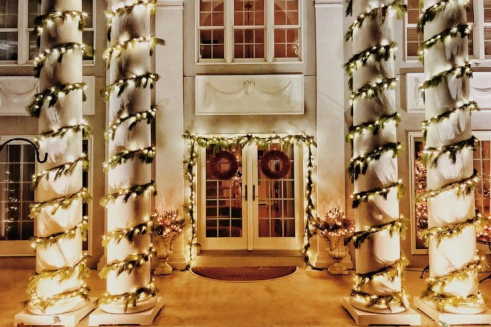 live lit garland on the front of a home for christmas