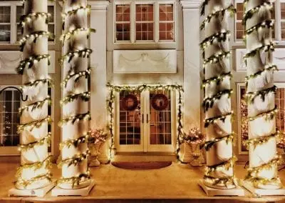 Live garland and lights on pillars in front of a Schenectady area home