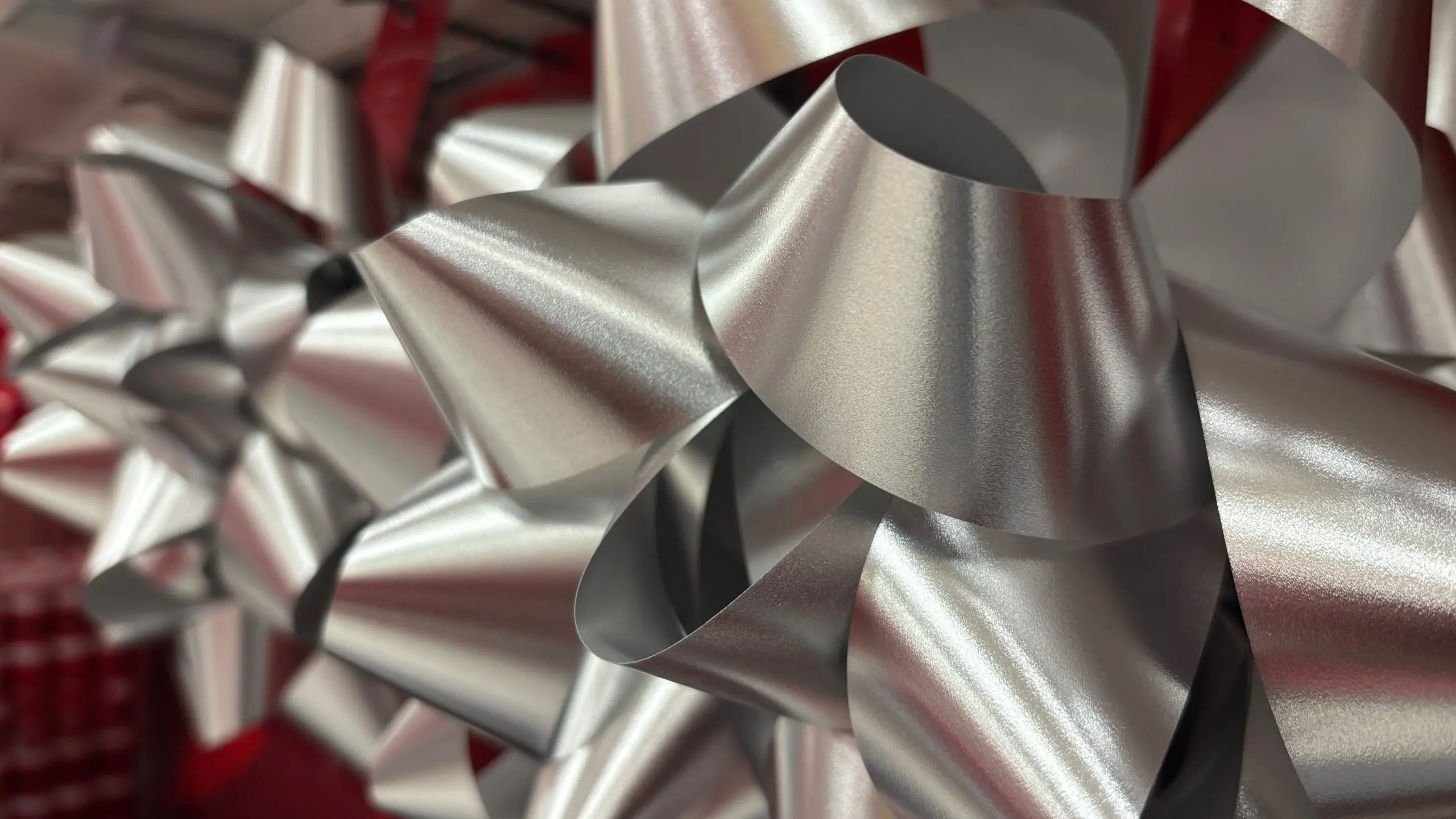 Close-up photograph of silver ribbon bows on wrapped gifts