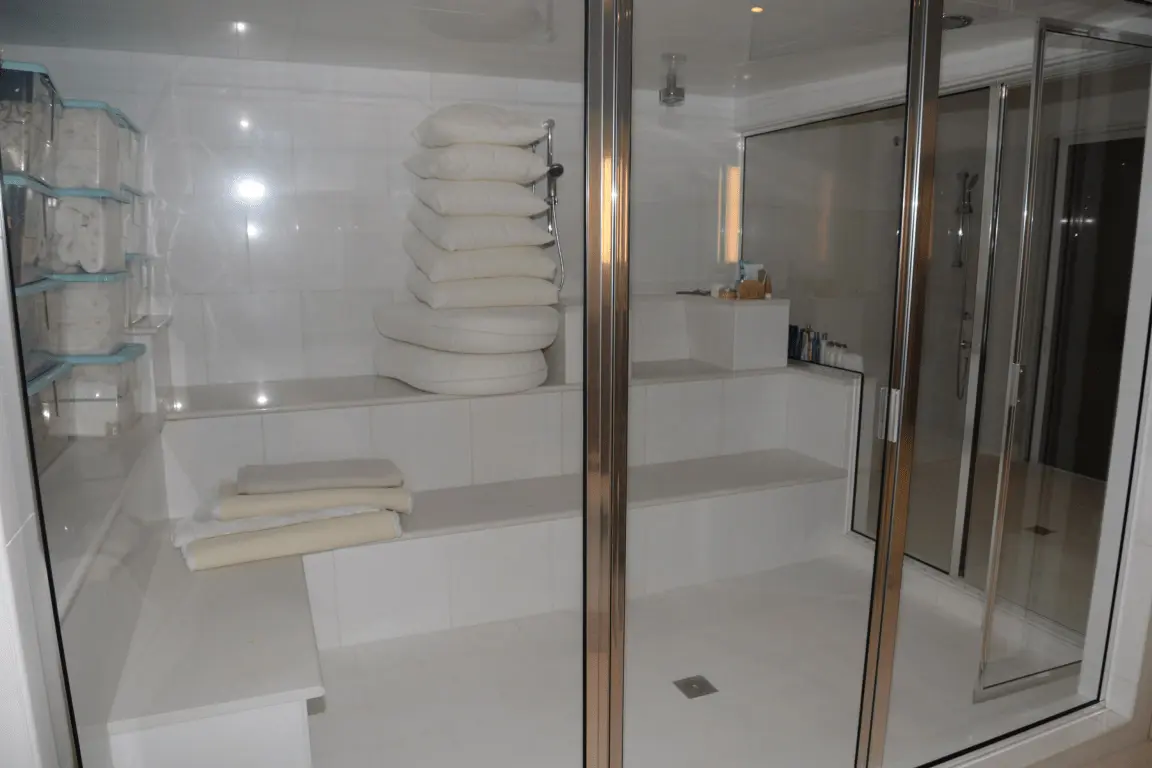 Clean white spa towels in a bright tiled bathroom