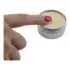 A fingertip touching the surface of Thrive Botanical Balm in an open one ounce tin