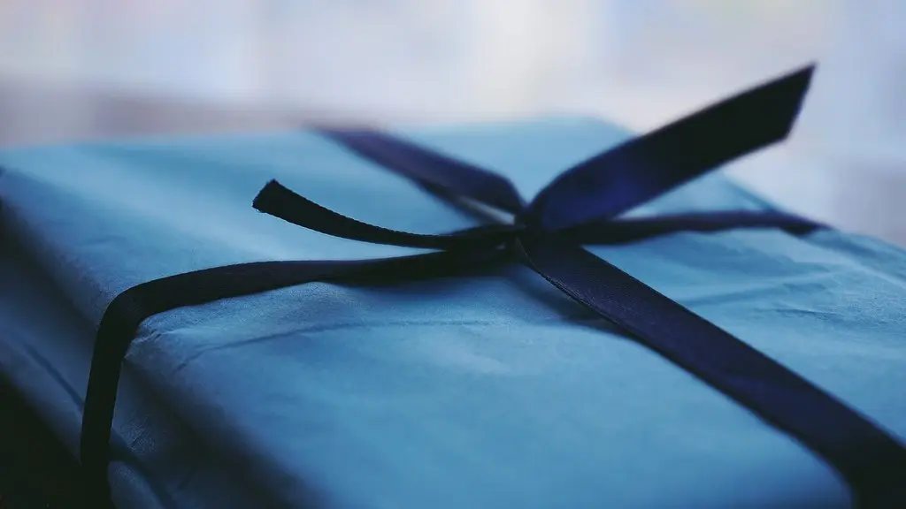 Close-up photograph of a blue paper-wrapped gift tied with a dark ribbon