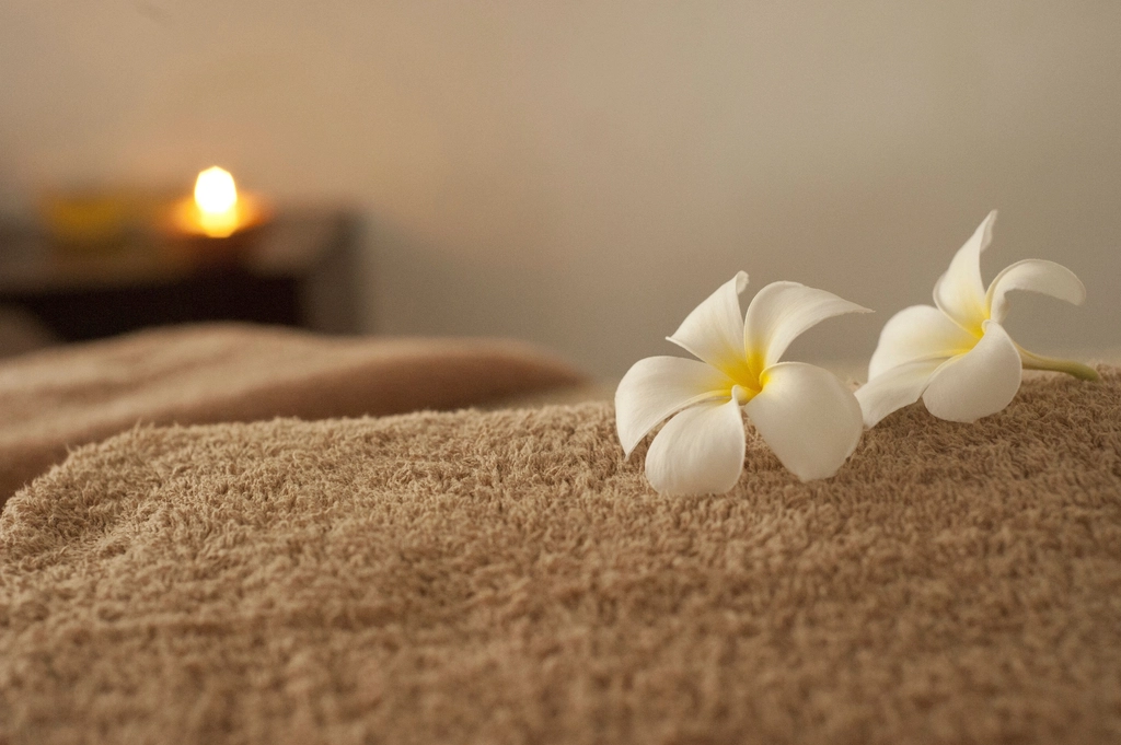 White flowers resting on a soft towel in warm spa-like light