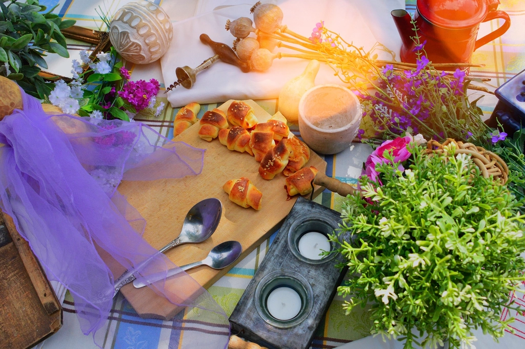 A summer picnic table with flowers, greenery, candles, and simple outdoor gathering details.