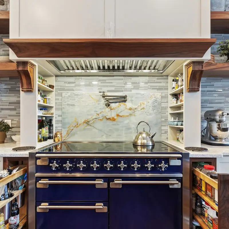 Custom kitchen renovation with blue range, pot filler and pull out spice cabinets