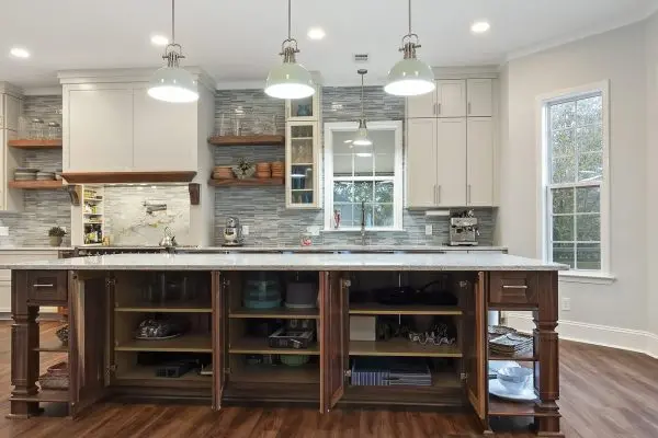 white kitchen remodel with large walnut center island and custom storage cabinets