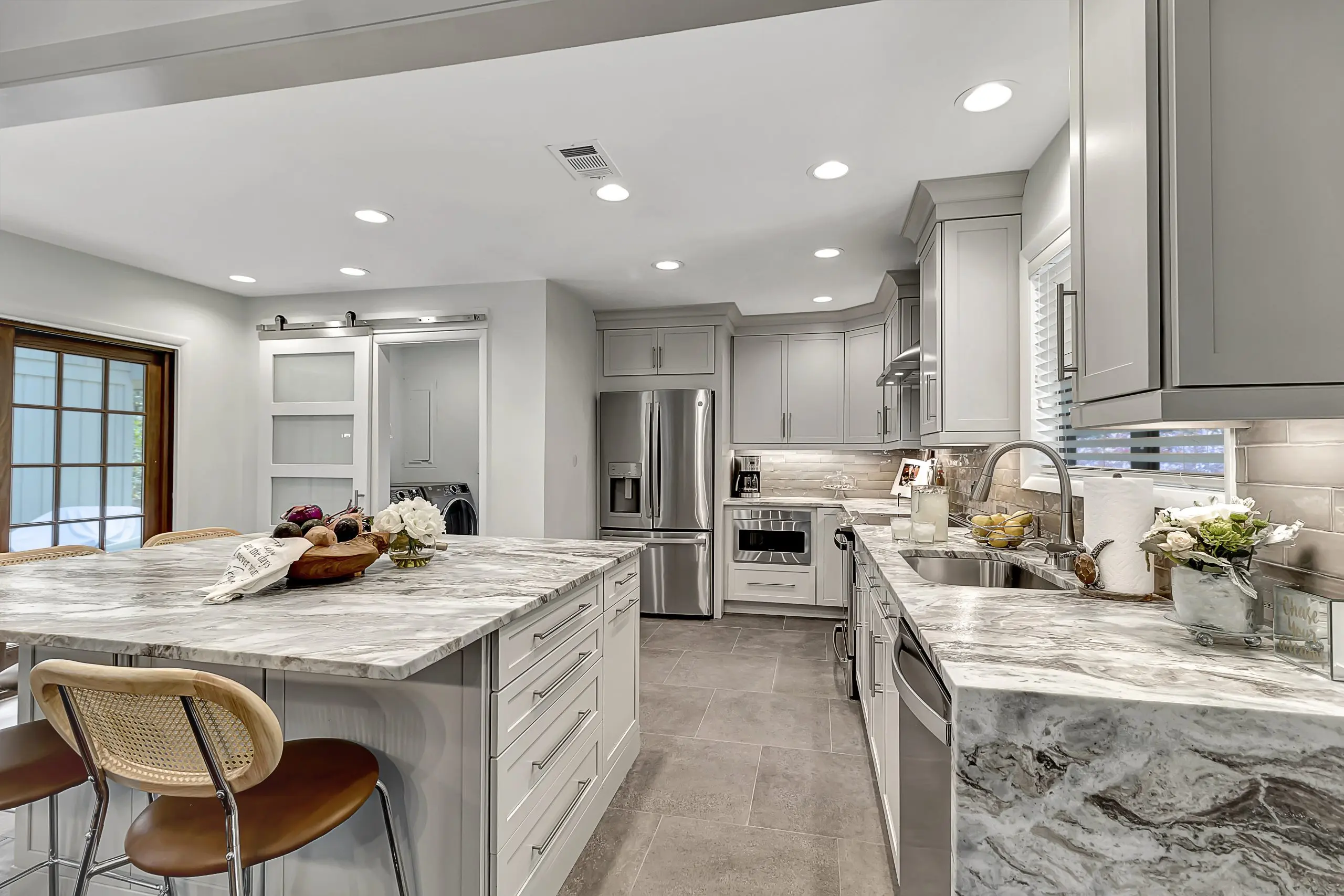 A newly remodeled kitchen with marble countertops and white cabinets