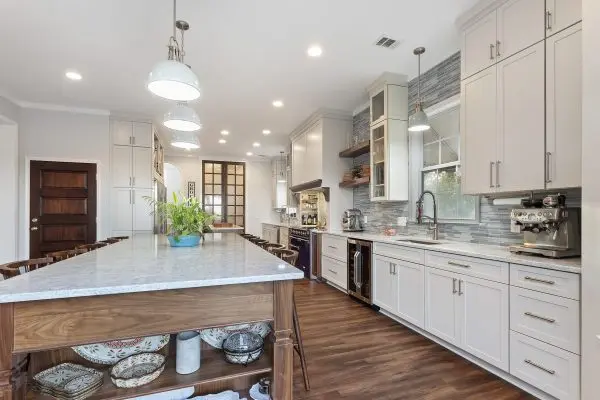 White custom kitchen remodel with large walnut island