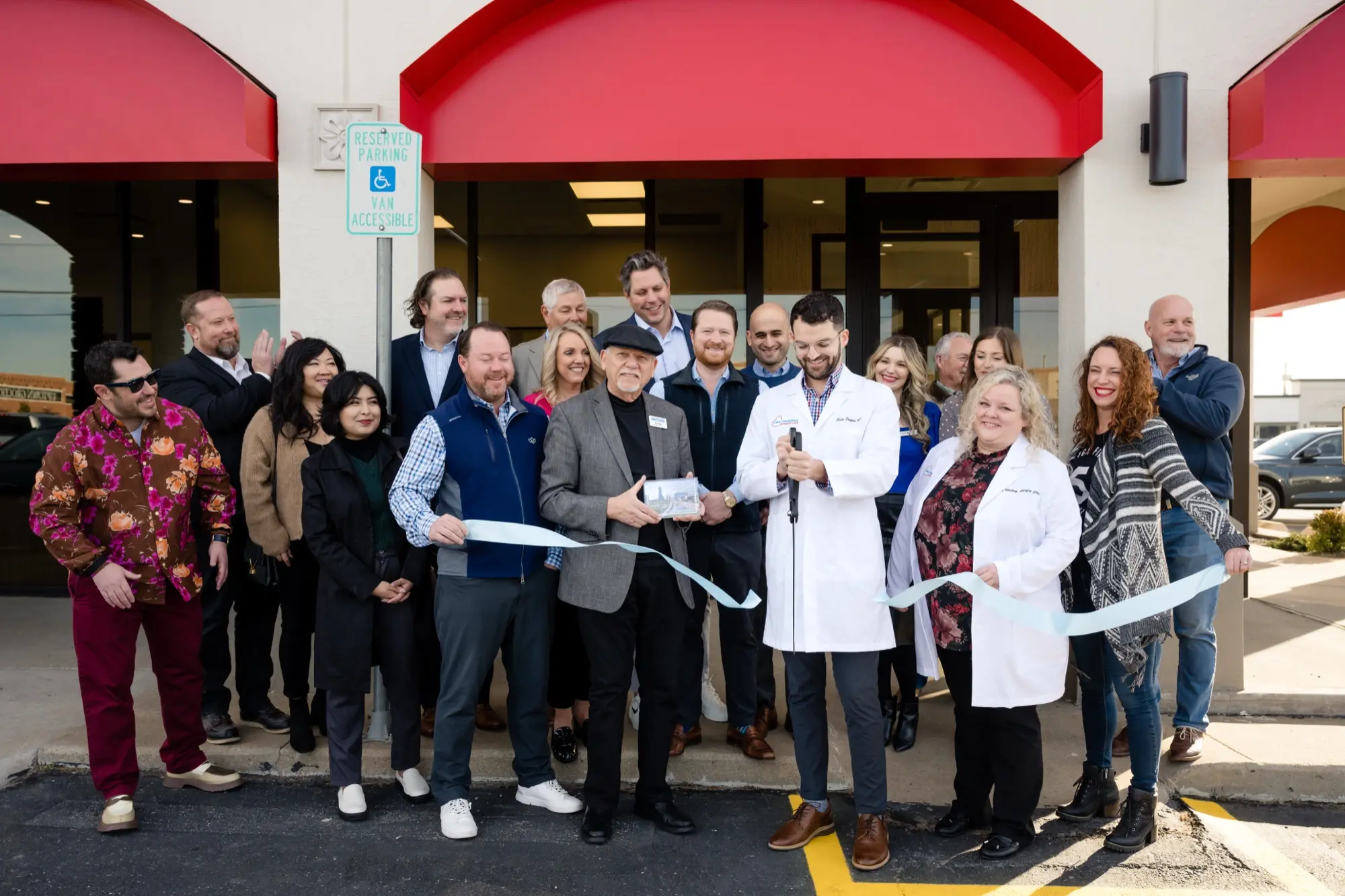 The Care+ Pediatrics team and community members cutting the ribbon at a clinic grand opening