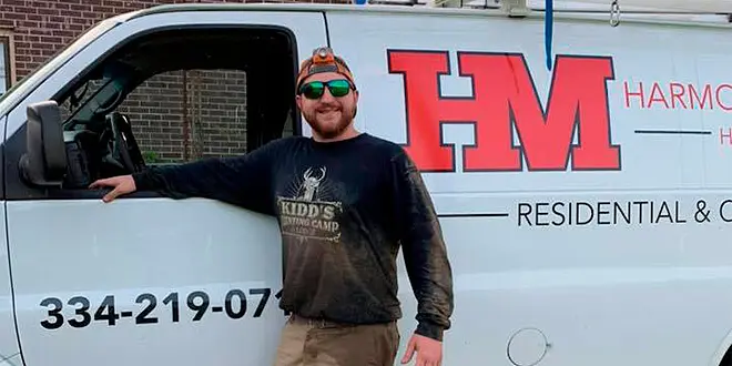 A man standing in front of a van with a Harmon residential & commercial sign.
