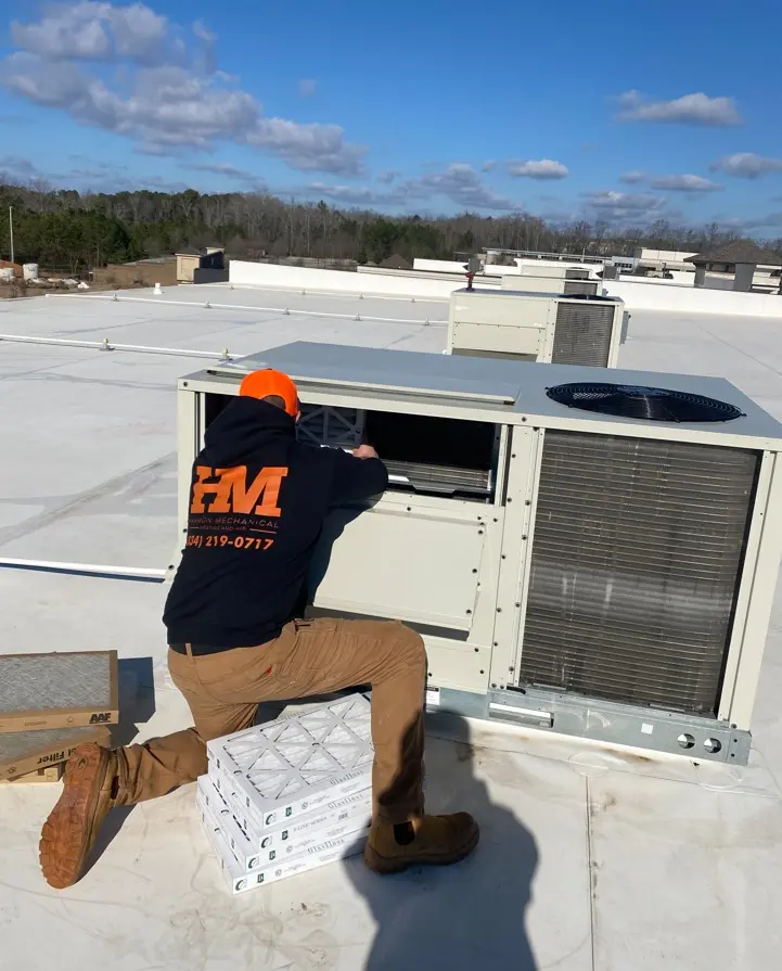 harmon hvac worker repairing ac unit on the roof